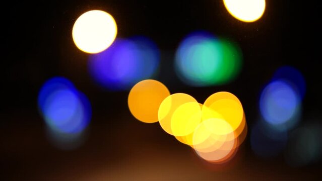 Bokeh car lights in the evening city. Defocused headlights and street lighting at night. Moving bokeh circles of cars at night. Blurred city traffic background