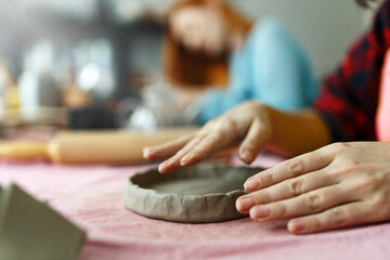 Obraz na płótnie Canvas Pottery workshop class. A pottery crafts dish from a raw clay. Creating ceramics