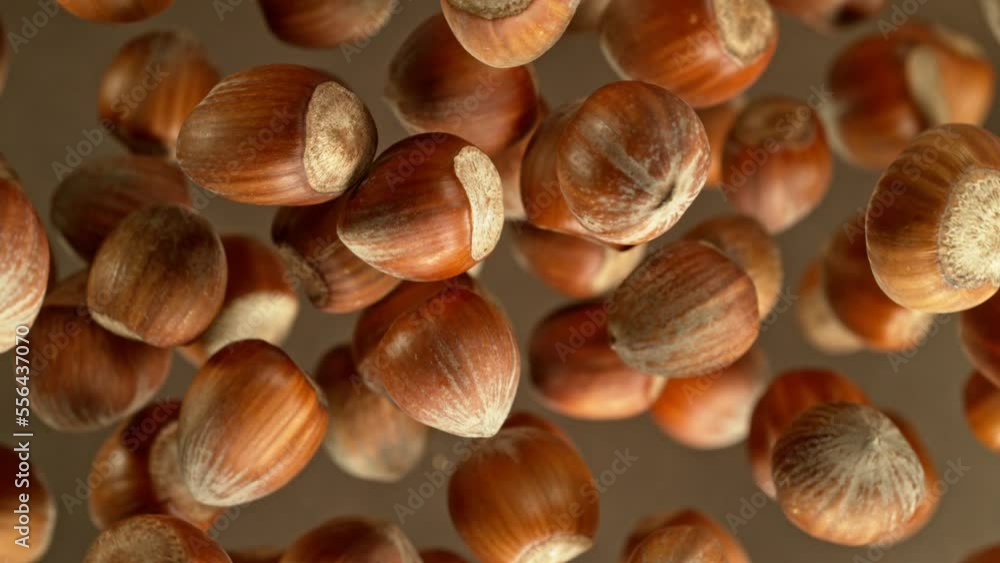 Poster super slow motion of rotating hazelnuts up to the air. filmed on high speed cinema camera, 1000fps, 