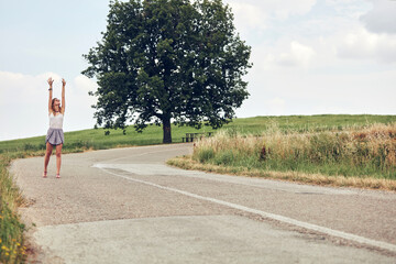 Young woman walking happy in the middle of a road.