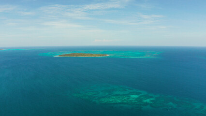 Tropical island with sandy beach by atoll with coral reef and blue sea, aerial view. Patongong...