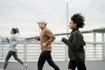 Young people runners run fast on the street, a hobby for every day. A group of friends workout fitness together in sportswear.