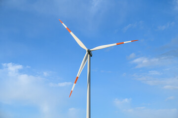 Windmills on Wind farm. Wind turbines against blue sky. Producing renewable energy. 