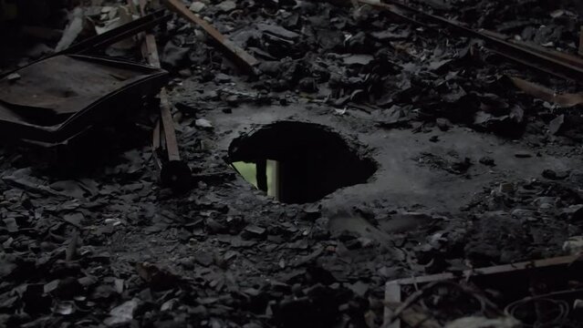 War in Ukraine. A hole in a floor in ruined apartment, aftermatch of russian missile strike on residential building with civilians. A destroyed Ukrainian apartment after a shahid drone hit