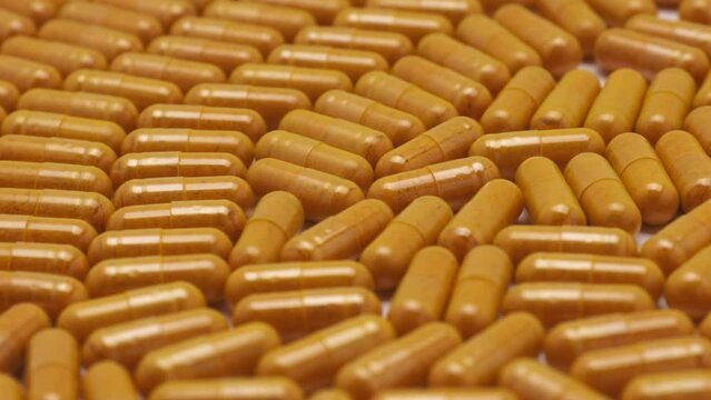 Close up rotation turmeric capsule. Food supplement, suitable for vegan.