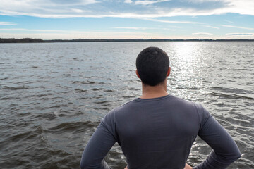 Jovem turista no cais a apreciar o lago Azur no País basco em França, num dia nublado