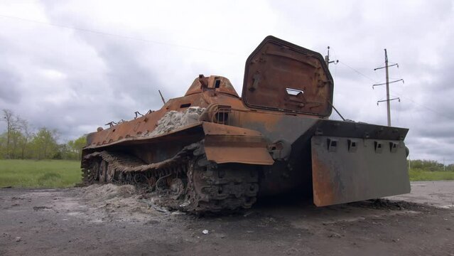 War in Ukraine. Destroyed russian tank on Ukrainian road. Rusted blown up military IFV. Wracked infantry fighting vehicle eliminated by Ukrainian military during de-occupation