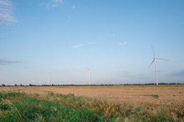 Windmills produce energy on countryside field. Ecofriendly wind turbines generate clean and renewable energy for supporting farmlands