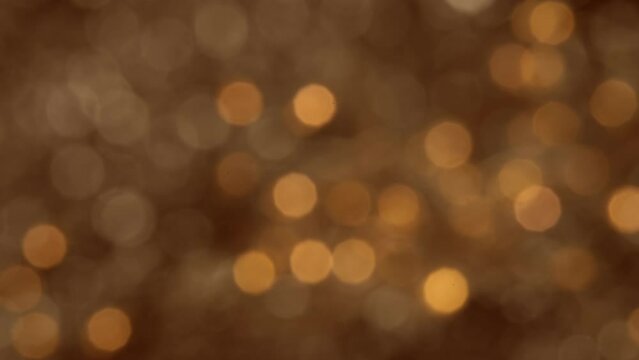 Abstract blurred glowing golden lights in slow motion. Bokeh Christmas and New Year background.
