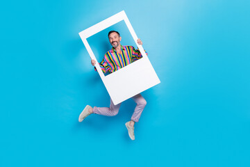 Full length photo of retired positive man have good mood fun wear stylish vintage outfit hold image cadre isolated on blue color background