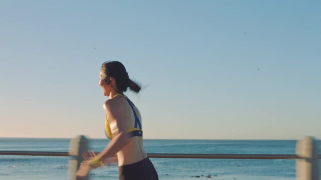 Fitness, asian woman and running by the beach for exercise, training or cardio workout in the outdoors. Active Japanese female runner in sports sprinting, exercising or run for healthy body by ocean