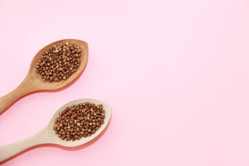 Small grains of natural brown buckwheat in a wooden spoon
