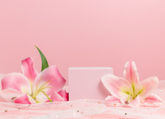 Obraz na płótnie Canvas Cube podium with pink lilies on pink background. Display with flowers for product presentation. Romantic, valentine concept