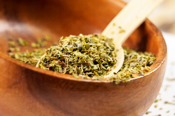 Crushed oregano spice on a wooden bamboo spoon