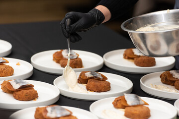 chief serving herring with potato Kroket croquette Dutchs favourite snack deep-fried ragout filled snack coated with breadcrumbs