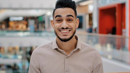 Obraz premium Happy emotional enthusiastic surprised amazed Indian Hispanic ethnic man manager male guy entrepreneur looking at camera with surprise facial delight winning victory luck success business offer win
