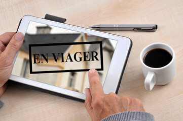 Concept de vente en viager avec quelqu'un cliquant sur une tablette tactile
