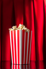 popcorn box on theater stage with red curtains and black background