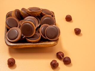 Chocolate candies on an orange background. Sweets with caramel. Round chocolates.