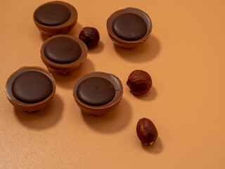 Chocolate candies on an orange background. Sweets with caramel. Round chocolates.