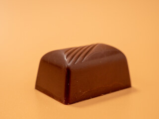 Chocolate candies on an orange background. Candies with filling.