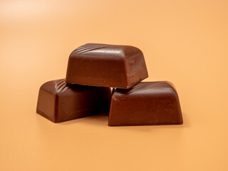 Chocolate candies on an orange background. Candies with filling.
