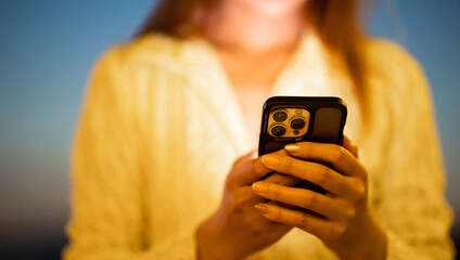 Close-up shot of woman hand in yellow shirt using smart phone lights in night city