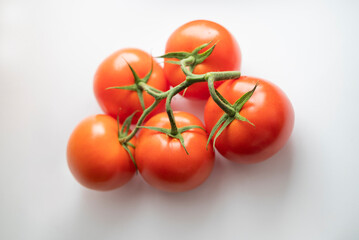 sprig of red ripe tomatoes on a white background