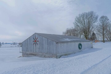 Old Gray Vintage Barn With Wreath And Barn Quilt at Christmas in the Snow