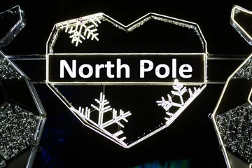 Foto auf Acrylglas North Pole written in a heart with snowflakes made with the glowing lights, with northern lights and black background © Michele Ursi
