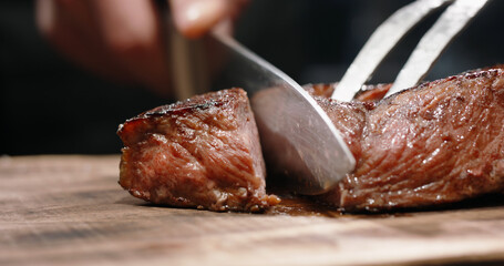 Juicy freshly grilled steak. Big piece of tasty meat cut. Macro shot of delicious meal on chef's preparation table - food and drink concept 