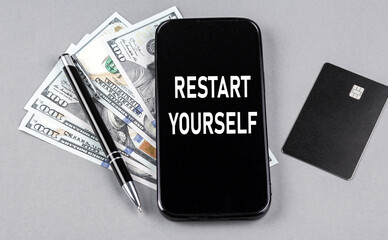 Credit card and text RESTART YOUR on smartphone with dollars and pen. Business