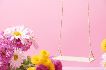 A swing with chrysanthemum flowers as a stand for your cosmetic product