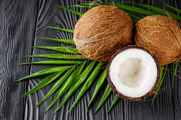 Fototapeta na wymiar fresh natural coconut and shavings dried flakes on black wooden background