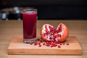 a glass of freshly squeezed juice and ripe pomegranate seeds