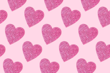 Repetitive pattern made of glittering hearts. Minimal composition on a pink background.