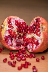 ripe pomegranate seeds on a wooden board