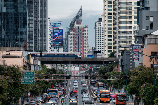 Crowded building with BTS skytrain and traffic jam on highway at business district
