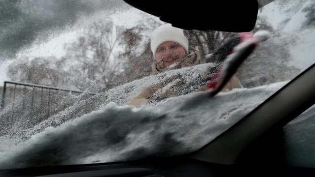 Man Cleaning Car Of Snow View From Inside