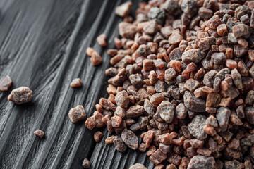 crystalline black Himalayan salt on a black wooden background