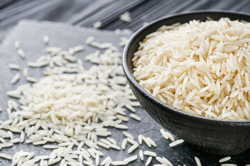 raw basmati rice on a black wooden background
