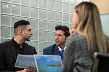New business people in the conference room are exchanging information with each other along with rehearsing important information before presenting work and new projects to the management team
