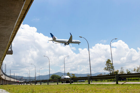 Boeing 767 da United Airlines em aproxima&ccedil;&atilde;o final para pouso no Aeroporto Internacional de Guarulhos, Brasil, com vista parcial da Rodovia H&eacute;lio Smidt.