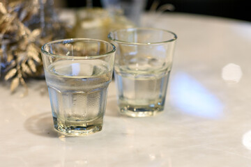 Dos vasos de agua fresca potable sobre mesa de mármol blanco. 