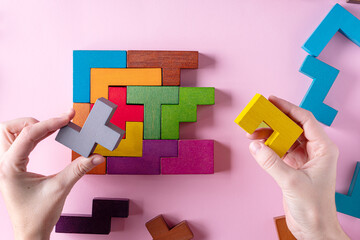 Different colorful shapes wooden blocks on pink background