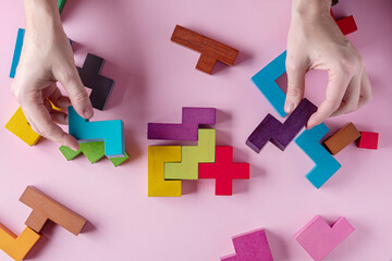 Different colorful shapes wooden blocks on pink background