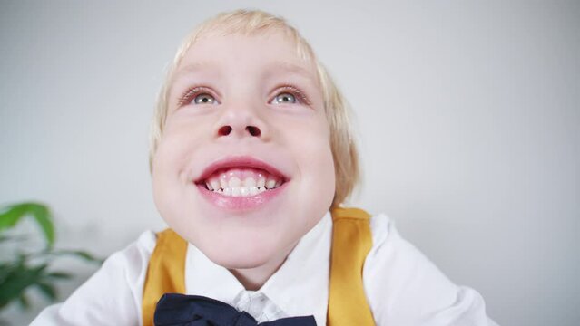 Smiling caucasian 5 years old boy makes funny face close to the camera. 