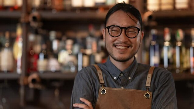 Night club concept of 4k Resolution. Asian bartender smiling with confidence in store. A group of specialized clubs that sell alcoholic beverages.