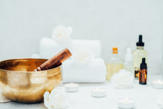 Spa and wellness massage kit with Tibetan singing bowl. Asian relaxing spa procedure with essential oils and sound healing therapy. Alternative medicine and body care. Selective focus, copy space
