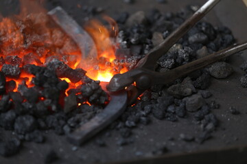 Blacksmith working at smithy workshop